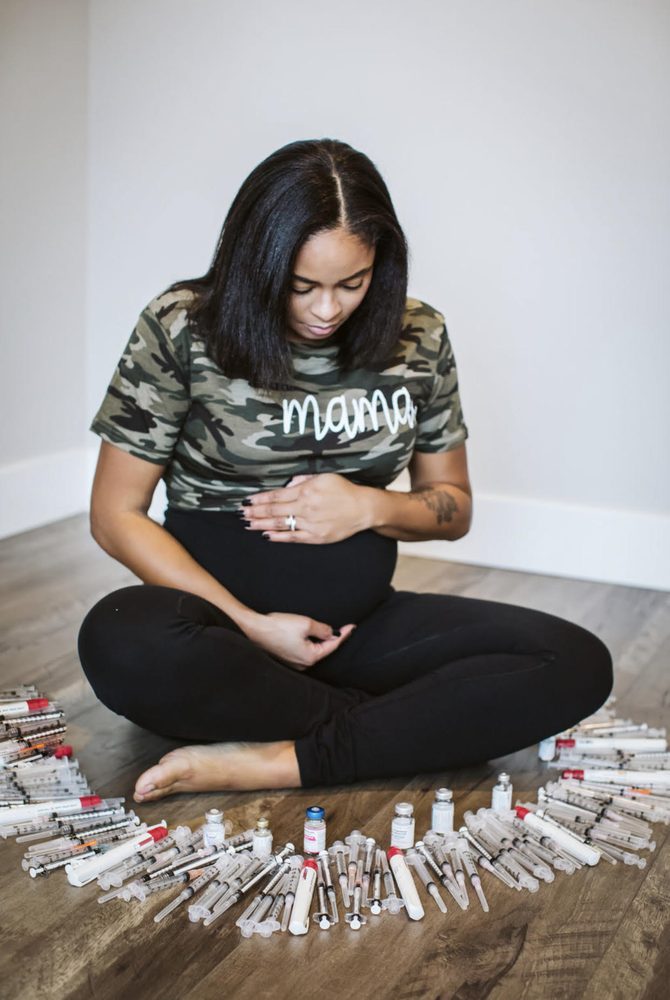 Denise seated with the fertility syringes and vials from her journey arranged around her